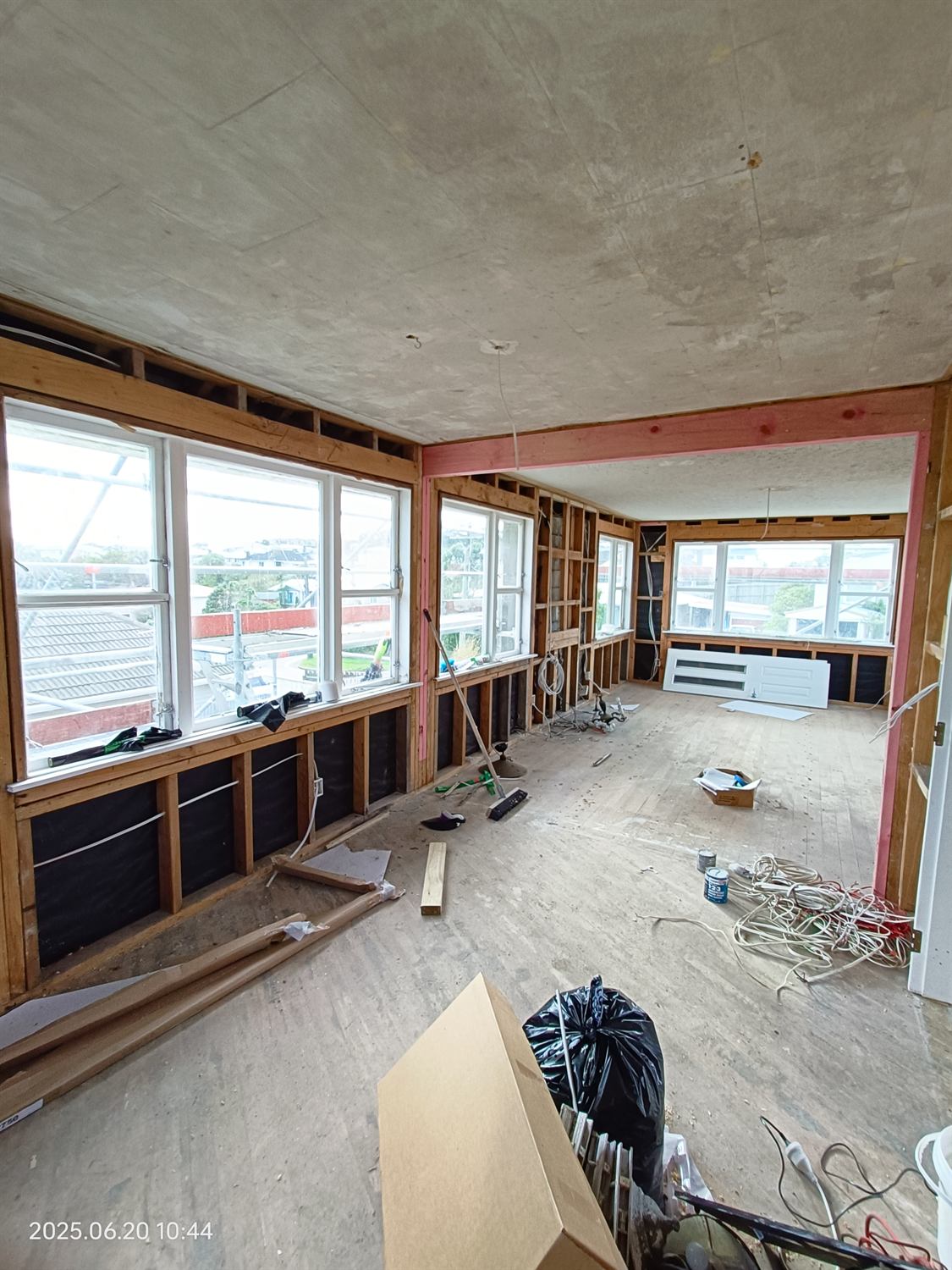 Lounge and dining area mid-renovation with wall linings removed